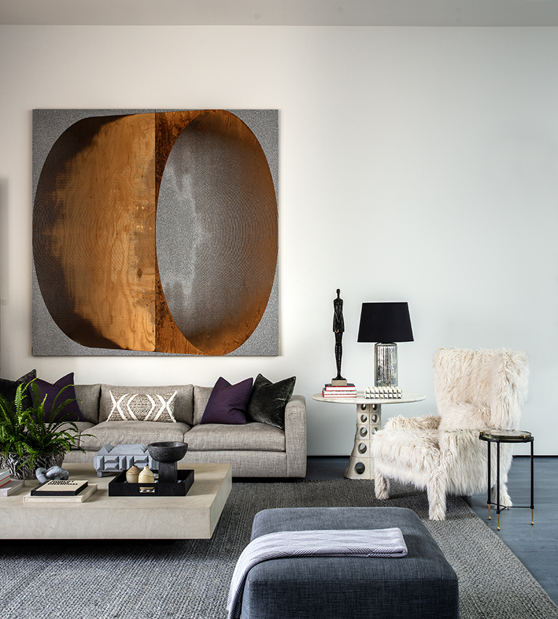 A cozy living room with a captivating large painting adorning the wall.