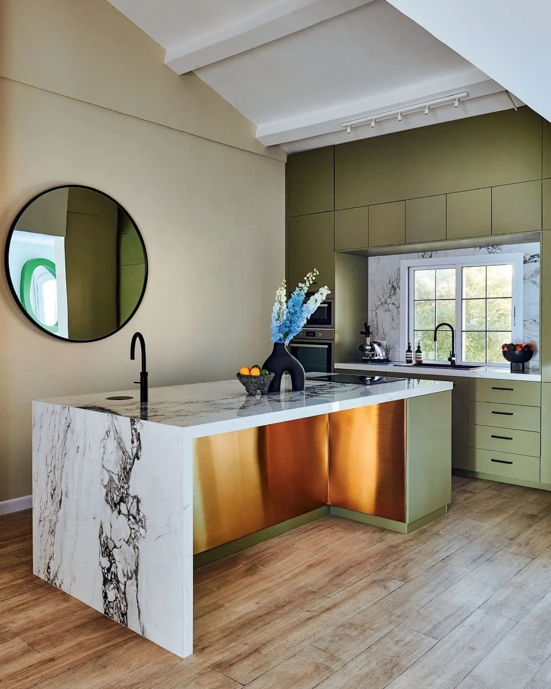 Kitchen featuringa a marble kitchen island and a circular mirror