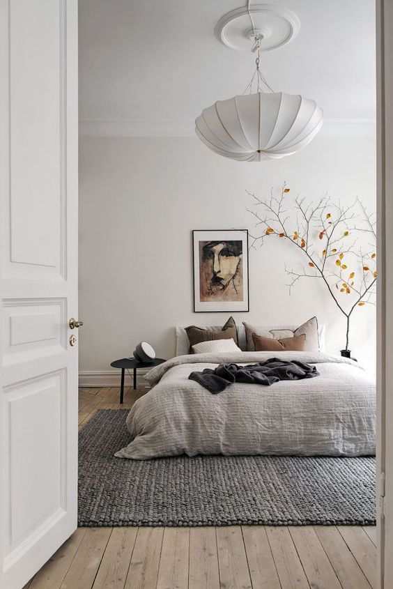 modern bedroom featuring a painting of a portrait in the wall next to the bed