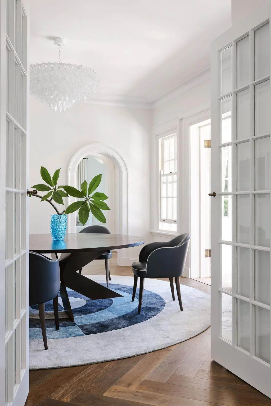 Dining rom featuring a circular black table and a circular rug in blue tones