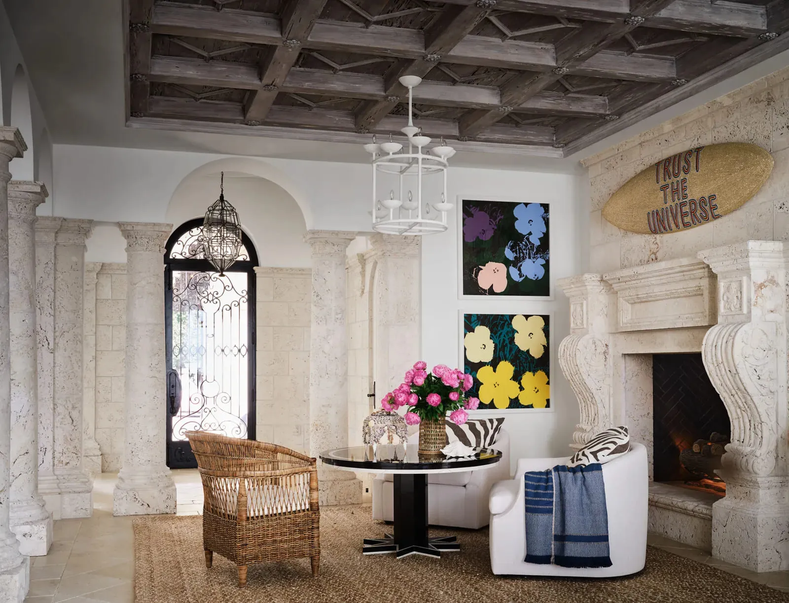 Ratten armchair and circular black marble table in the entry