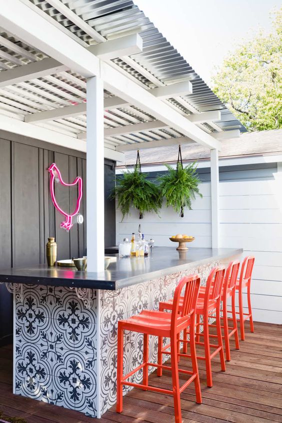 outdoor kitchen bar with orange bar chairs