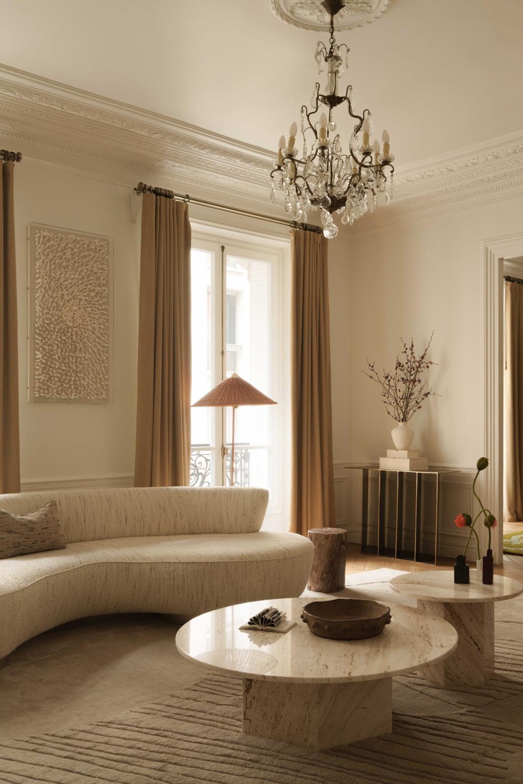 living room with a sofa and a center table, bege rug and sculpture light