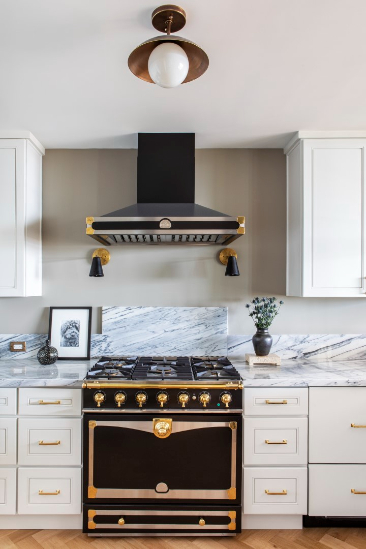 a white kitchen with gold and black details 