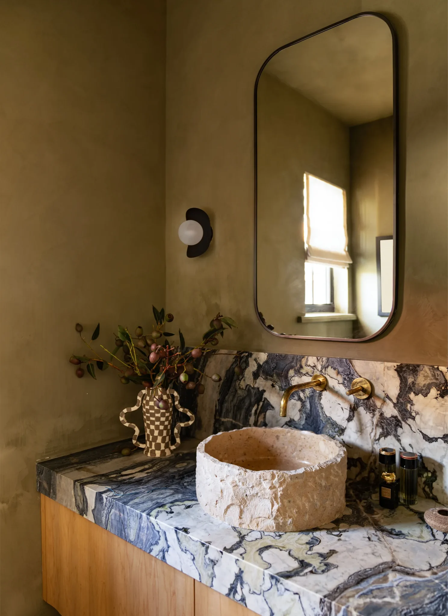 Bathroom counter with a marble countertop and a stone lavatory