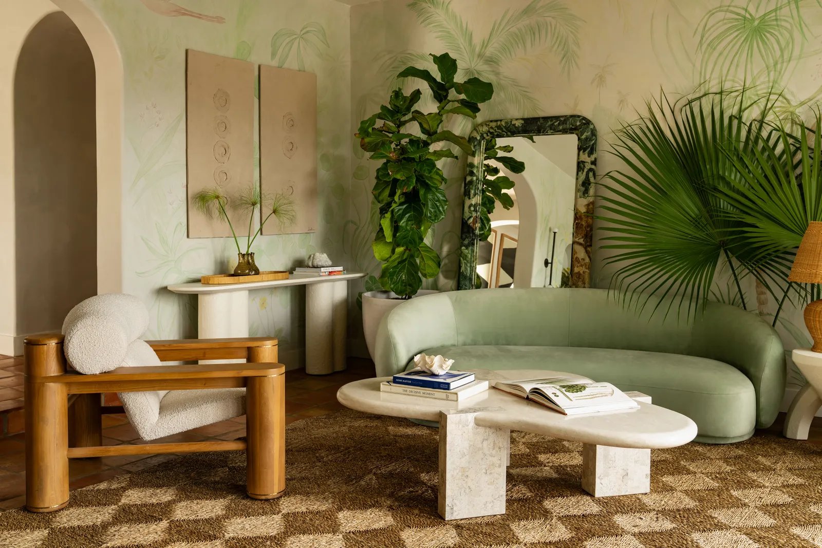living room featuring a stone center table, tropical wallpaper and a green curvy sofa