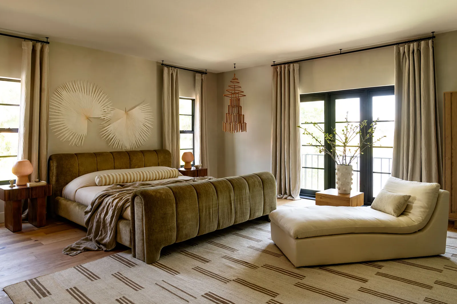 Main bedroom featuring a modern dark green bed and a beige daybed