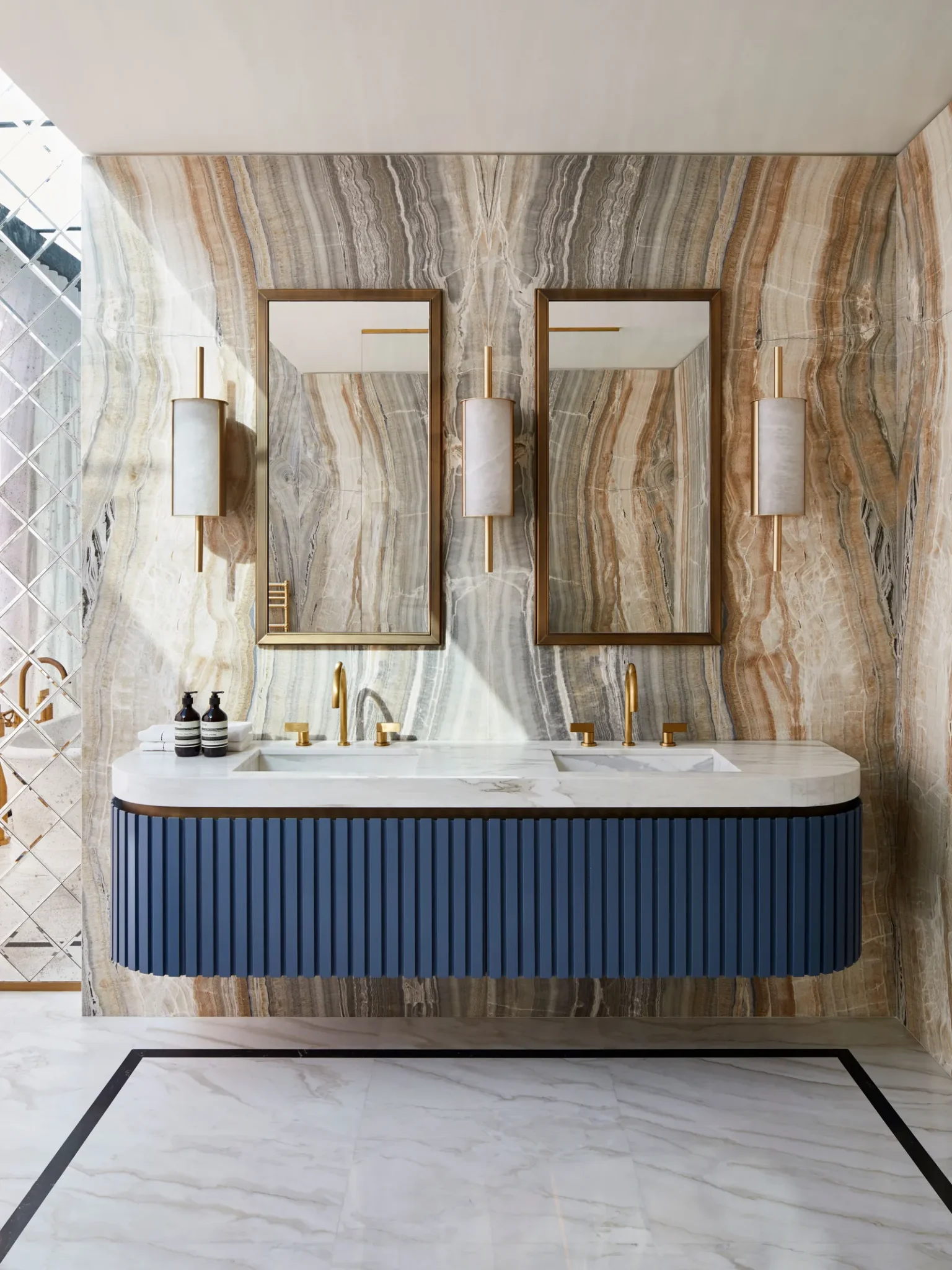 Bathroom featuring a custom notched wood vanity in French blue with marble and brass and sinks