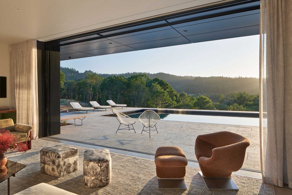 a modern home view to the pool and sorrounding nature