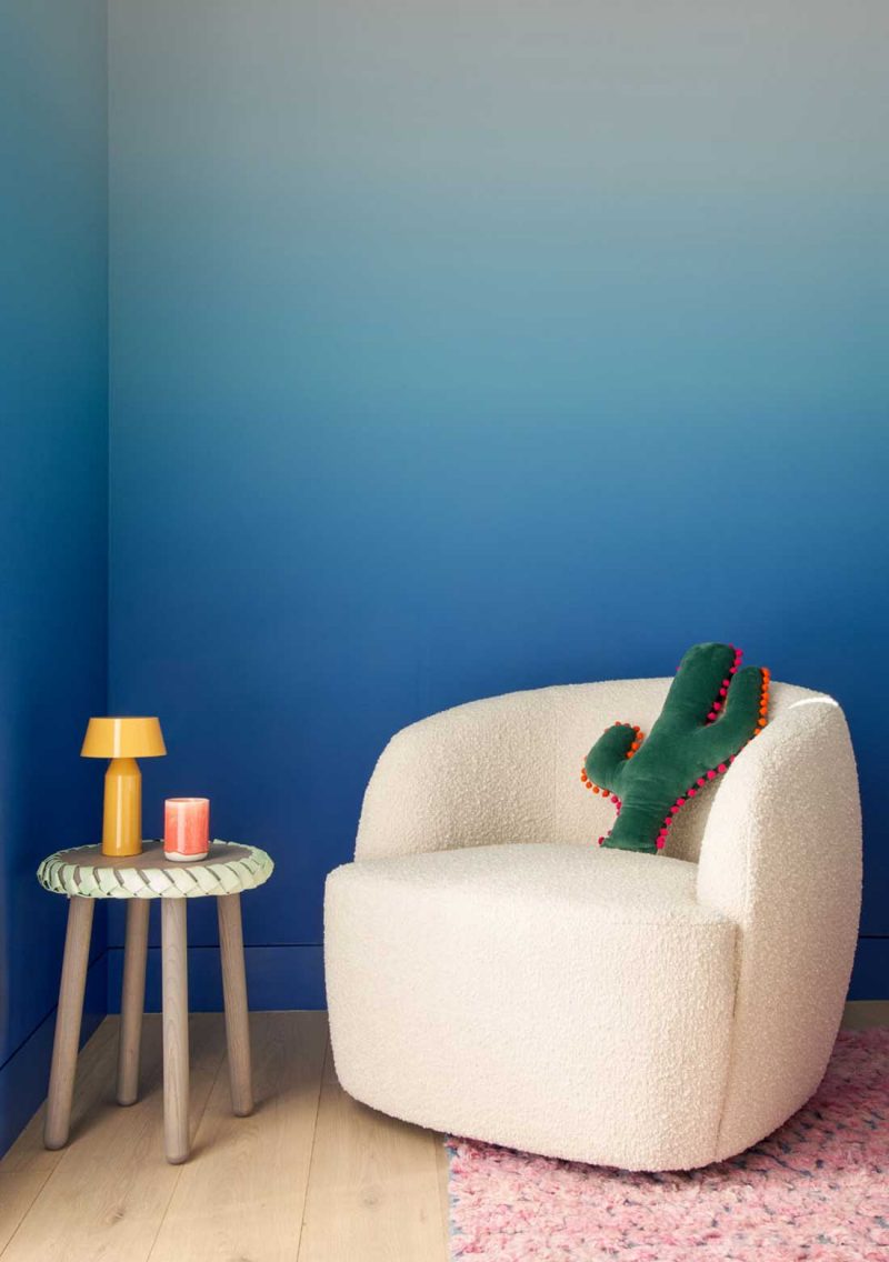 modern white armchair against a blue painted wall