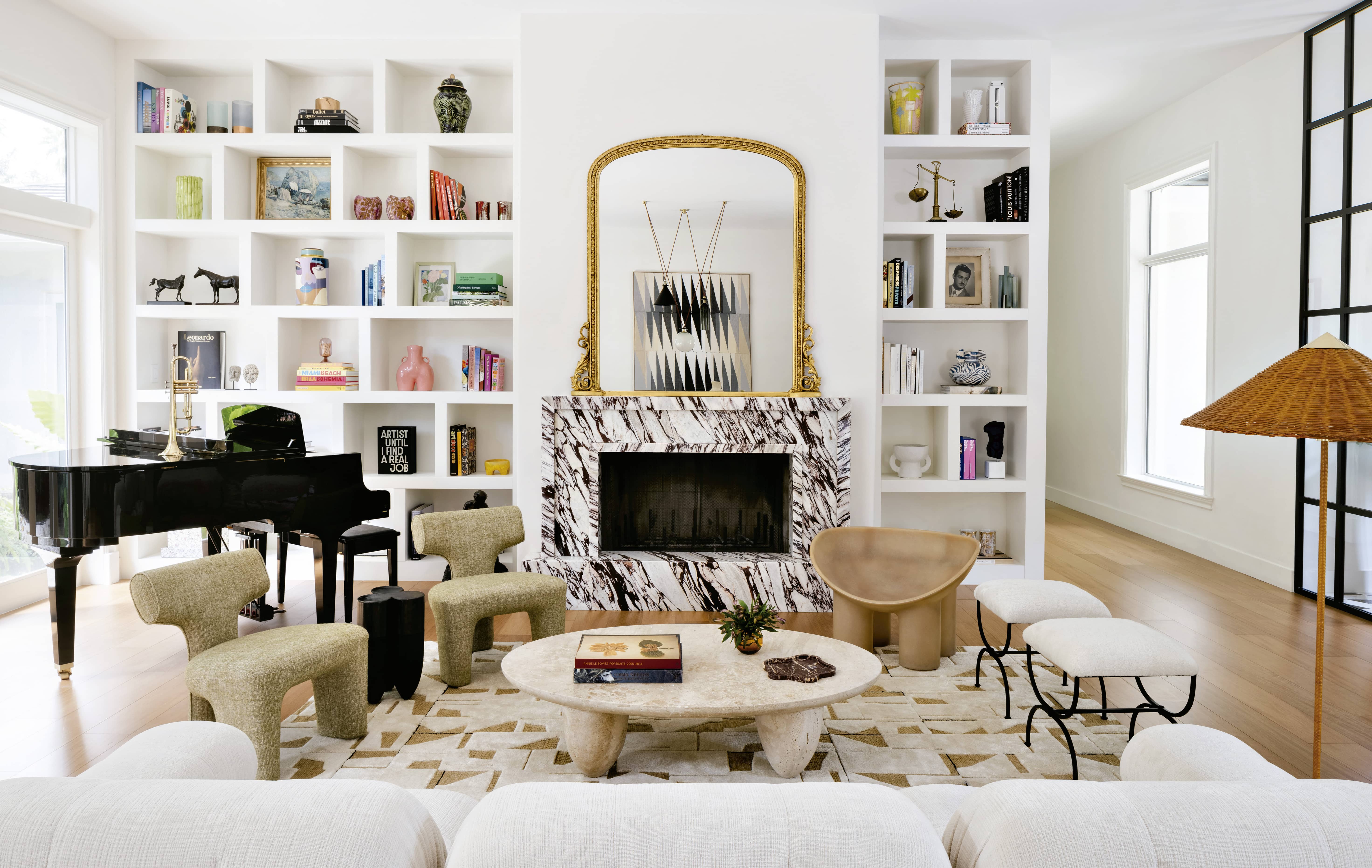 Must-Haves a spacious and stylish living room with a fireplace, built-in bookshelves, and a grand piano.