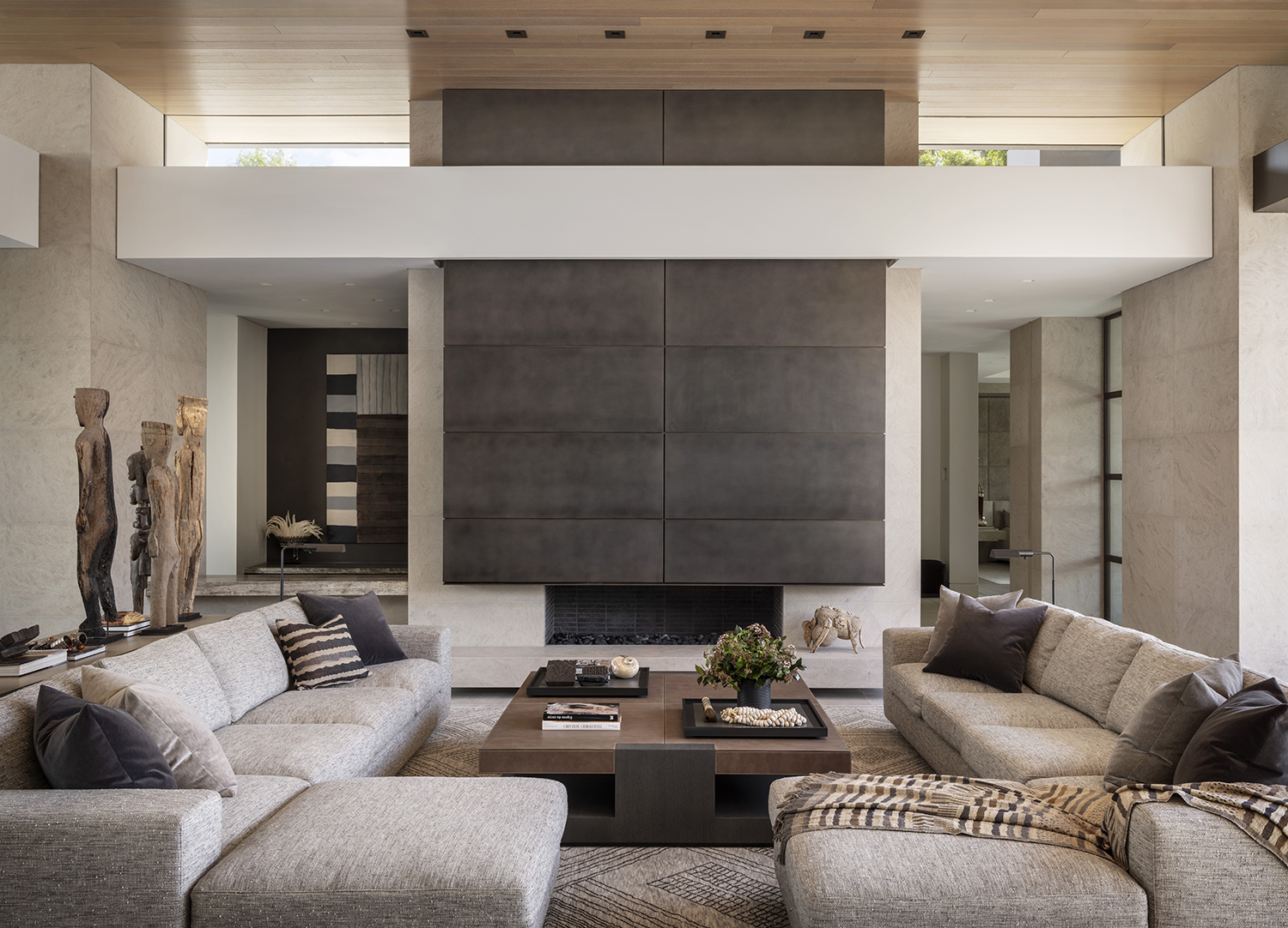 two grey L-shaped Sofas placed in symmetry and standing on top of a custom wool rug 