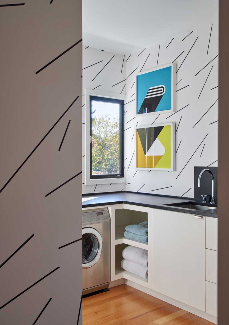 laundry room featuring an abstract wallpaper and some abstract art