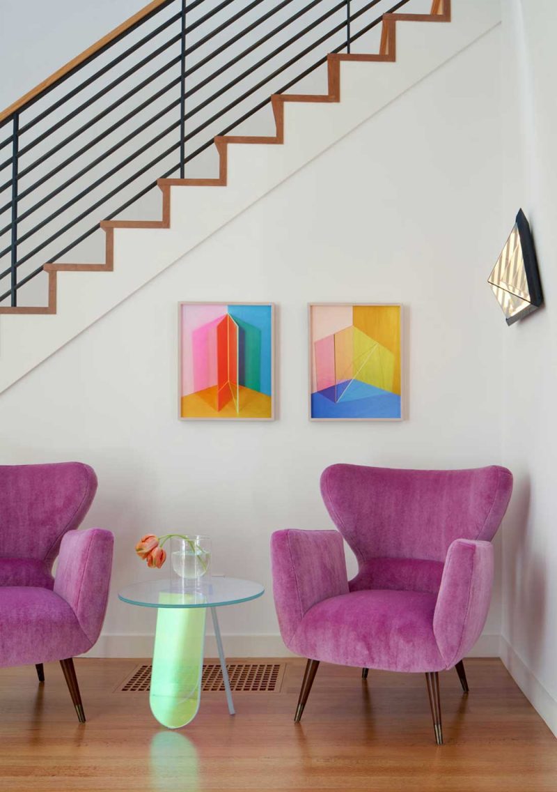 a pair of purple armchairs and a lime green sidetable