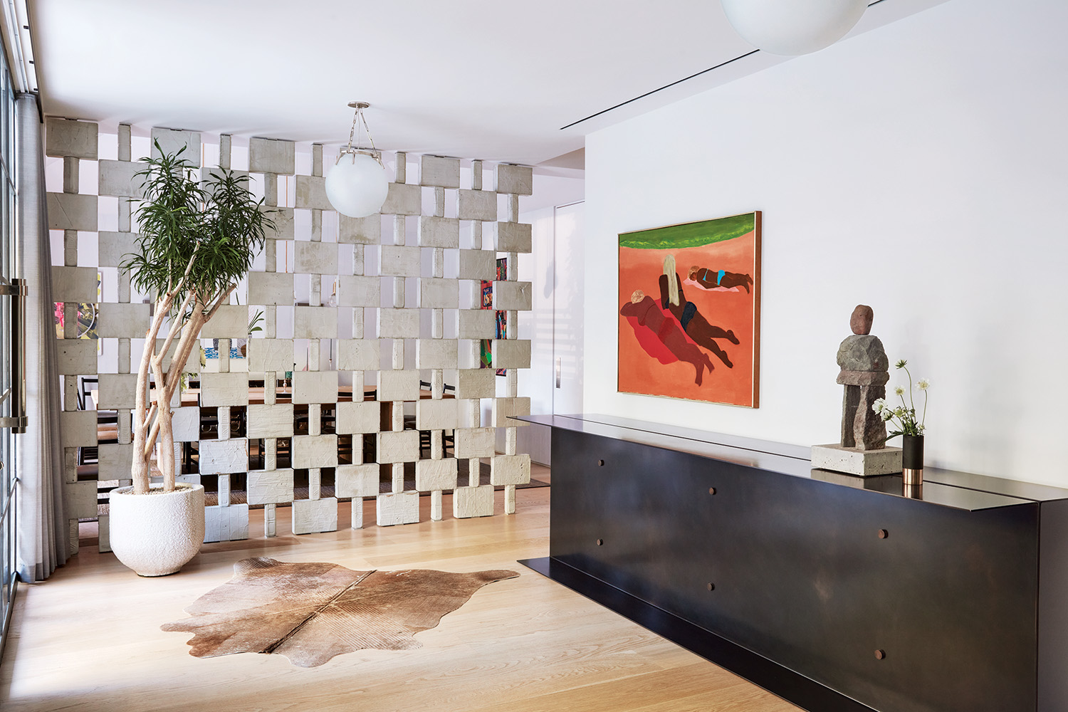 Entry featuring a painting by March Avery, and a custom-made steel cabinet that hosts an Ugo Rondinone sculpture