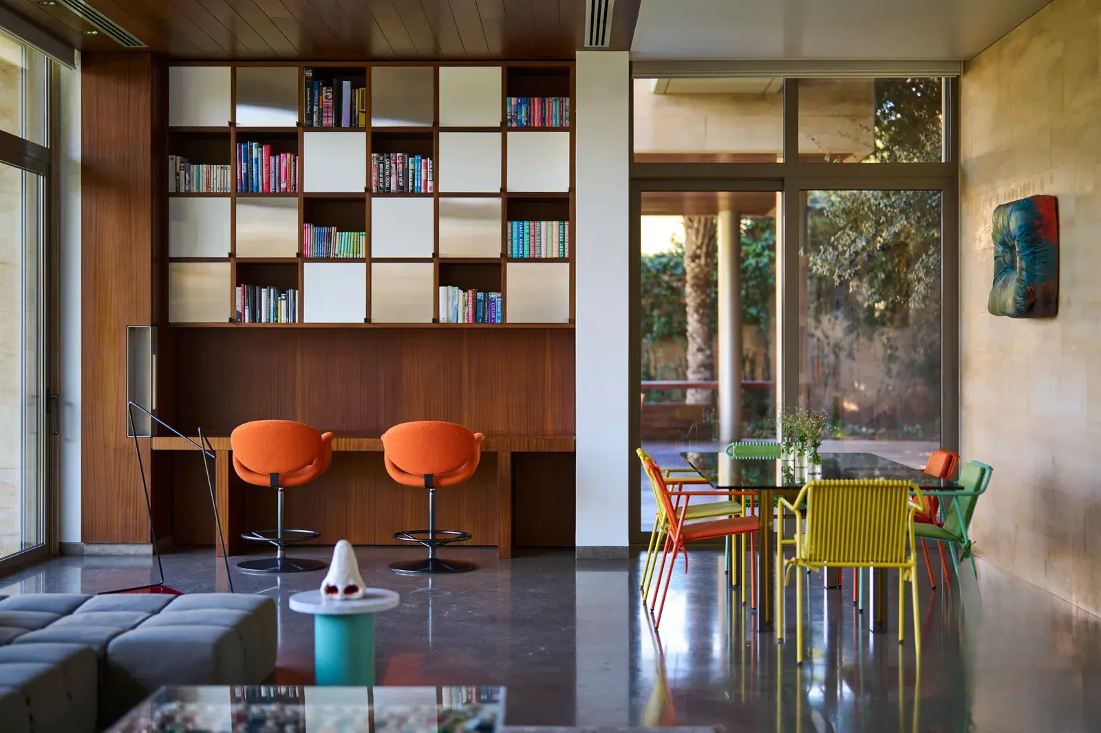 Library seating in the living room, featuring colorful chairs and bookshelves