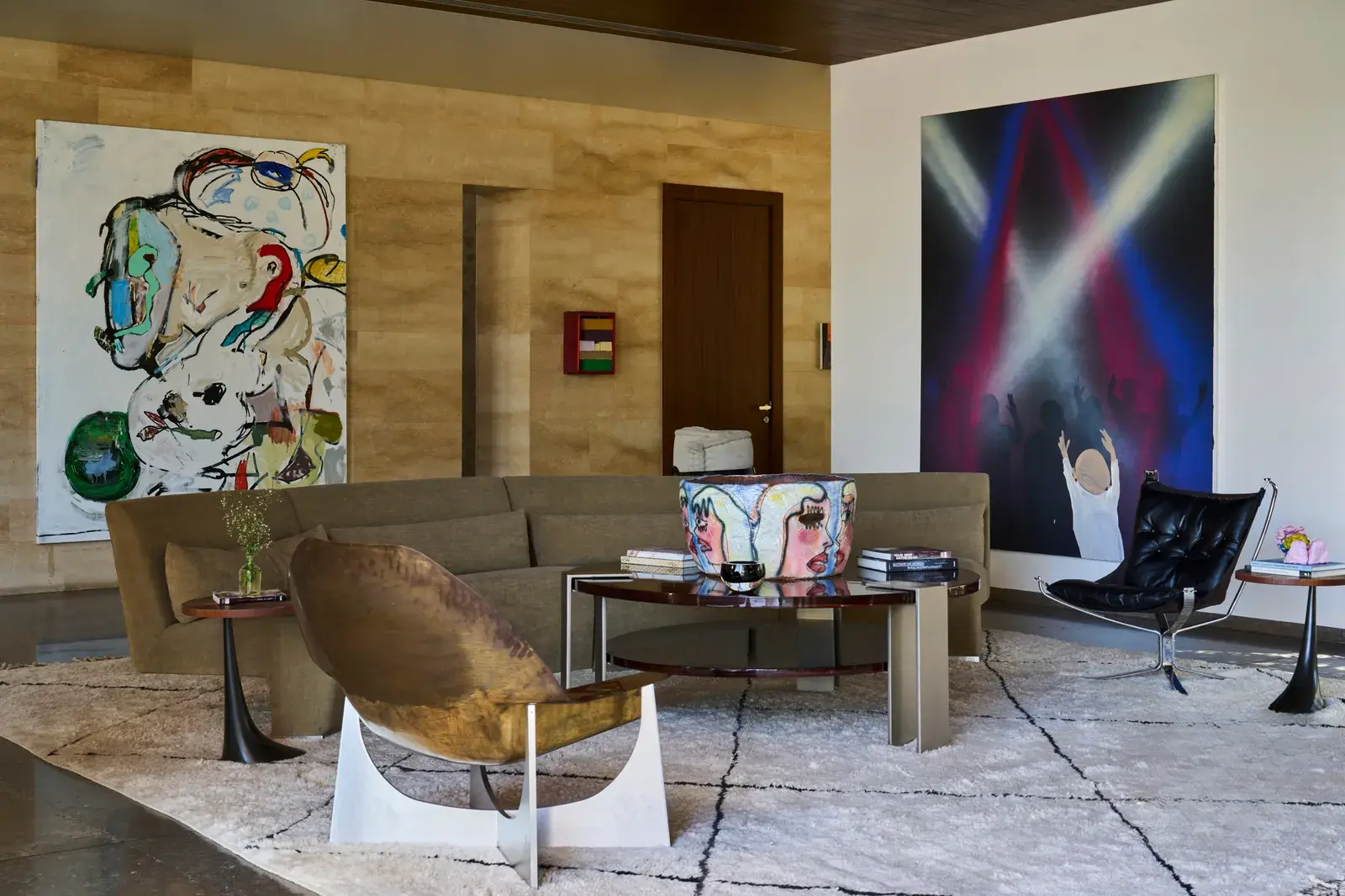 Art pieces on the walls, a round coffee table, and a handmade, unique armchair in the living space.