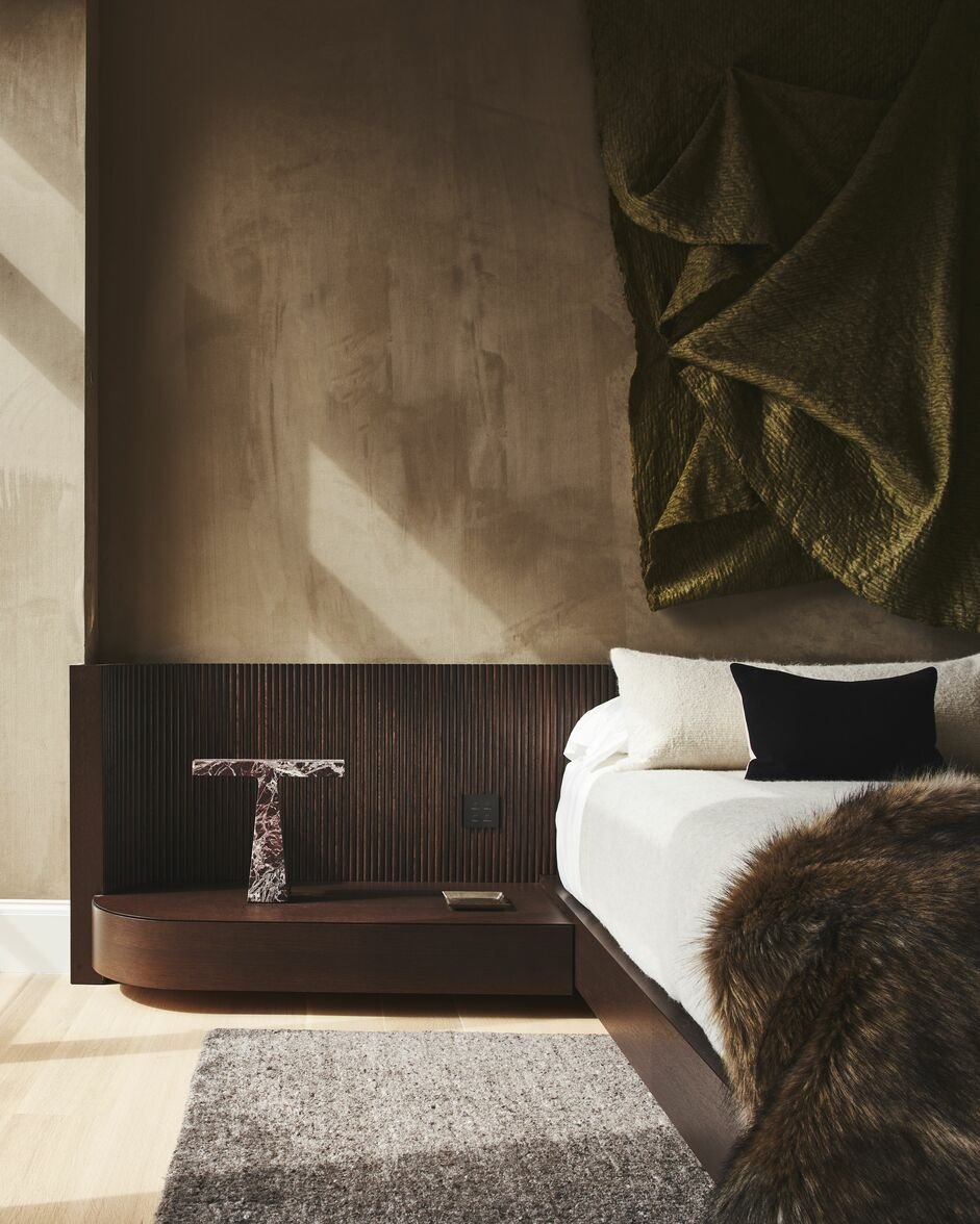 modern brown bed against a upholstered toupe wall
