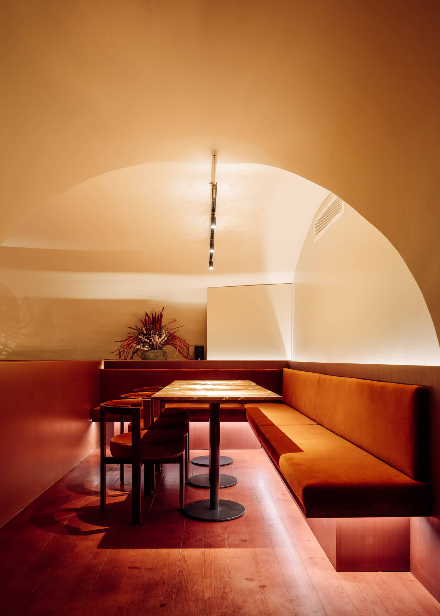 Intimate Dining Area in Rusty Red Hues at Nomada Restaurant in Lisbon