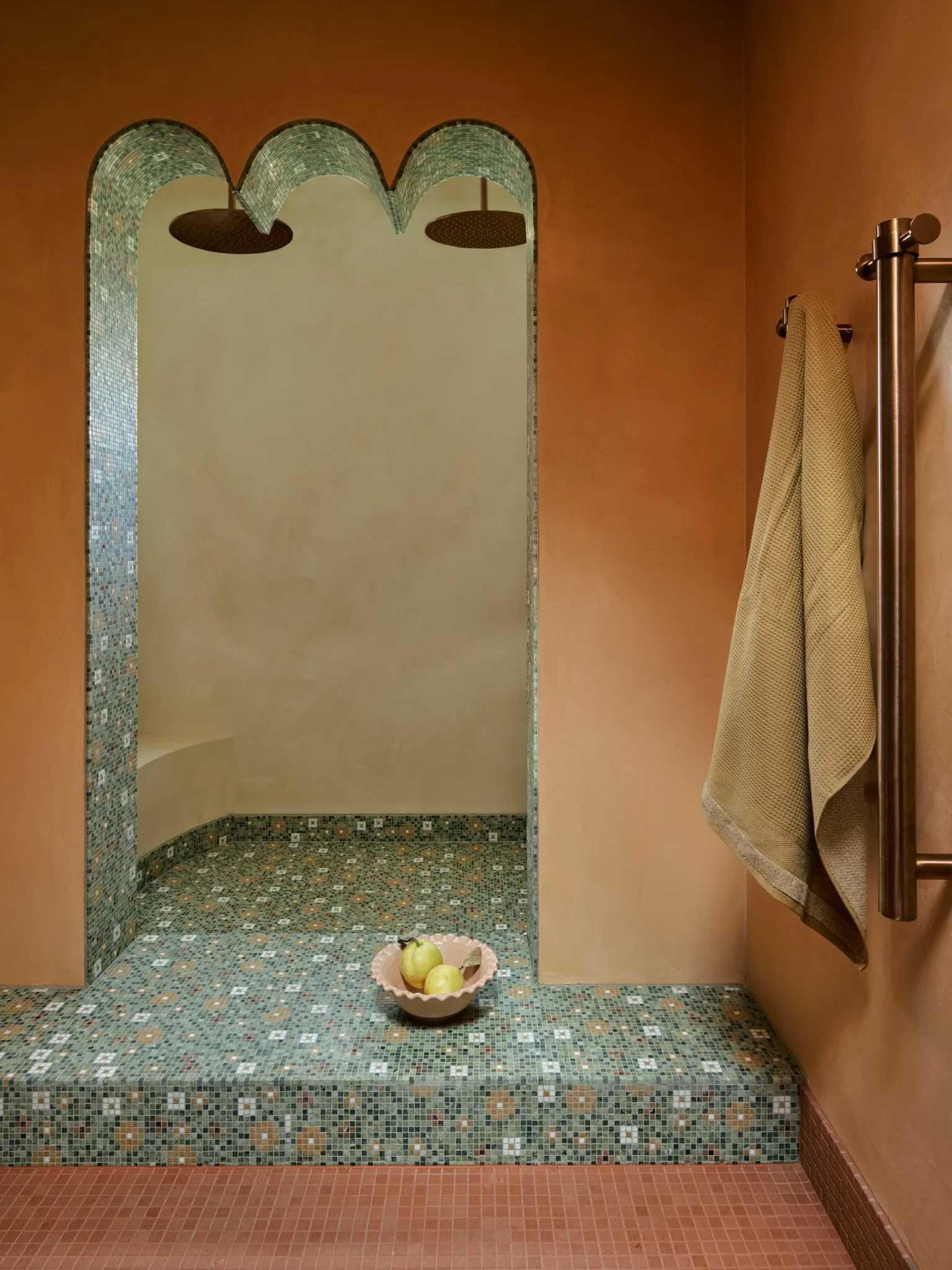 Bathroom addorned with green floring and terracota walls