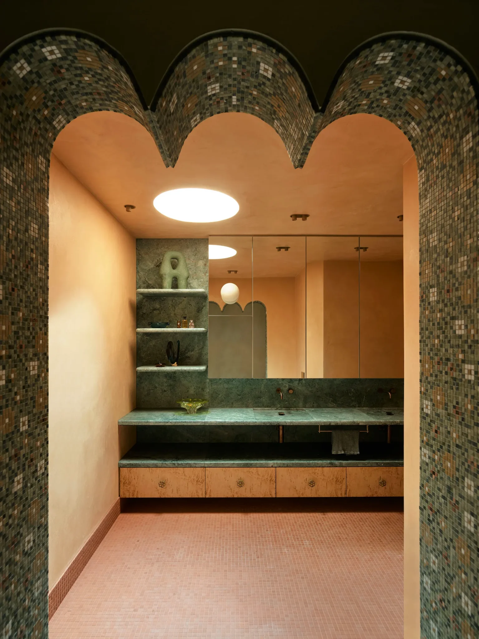 Bathroom addorned with terracota tile floring and green tile walls