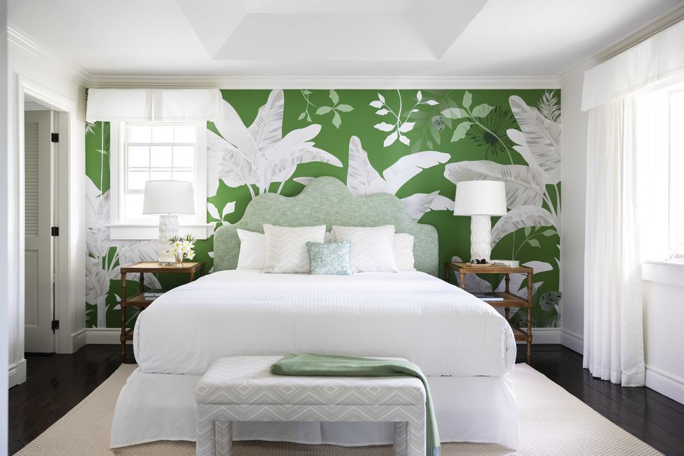 bedroom with white furniture and a green floral wallpaper