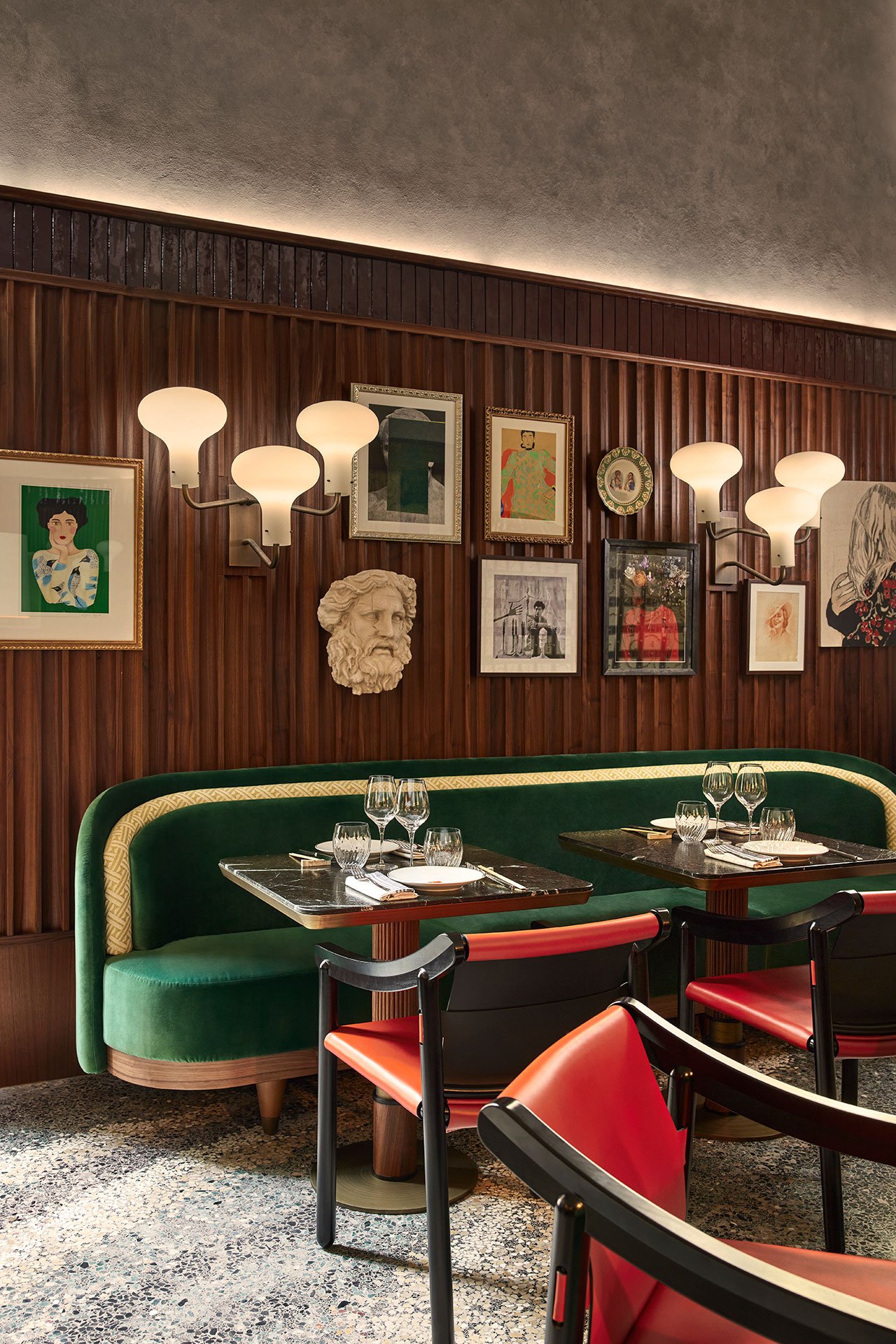 A restaurant wall featuring vintage wall lamps and an eclectic mix of art