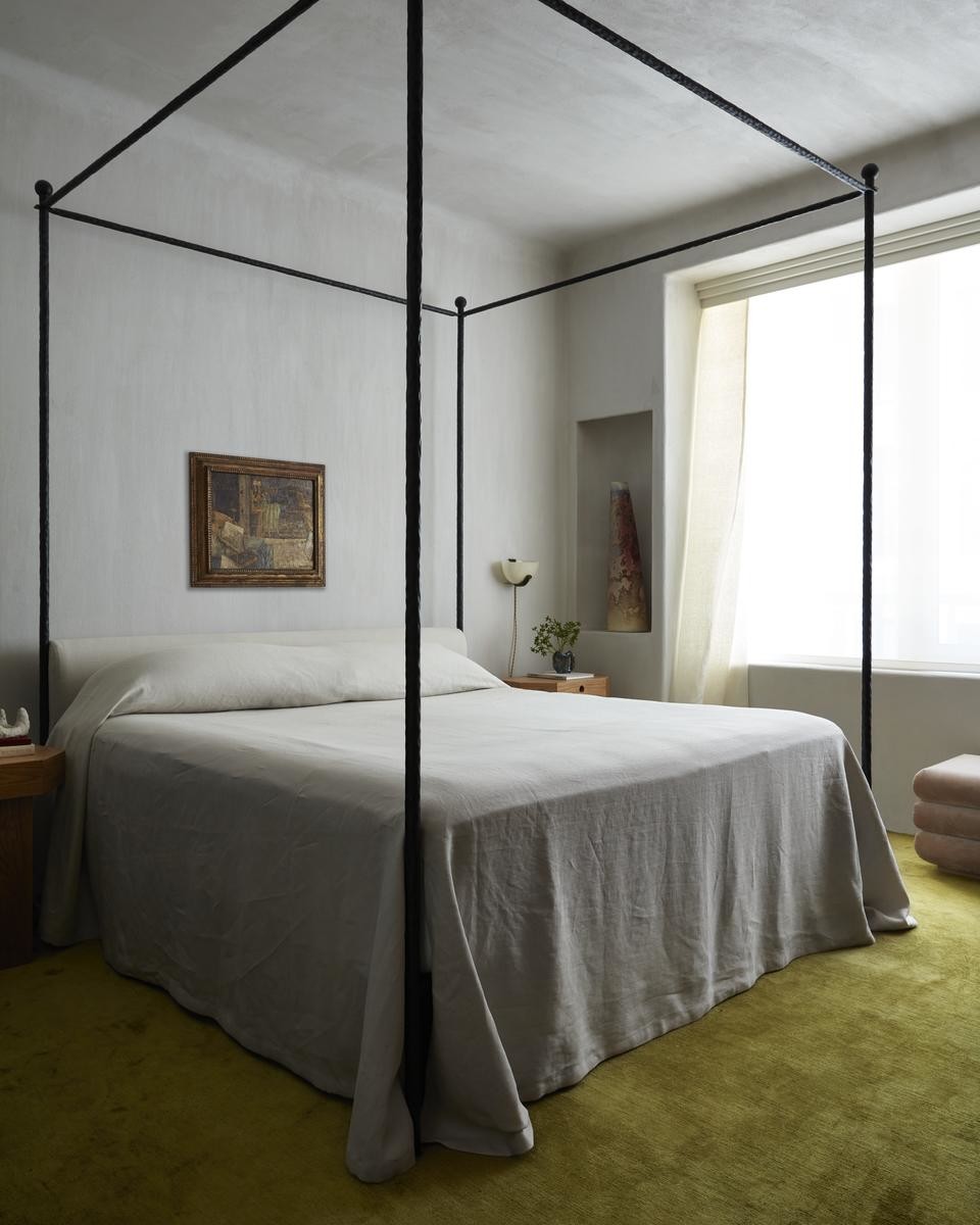 Bedroom featuring a hammered wrought-iron bed and a green wall-to-wall carpet