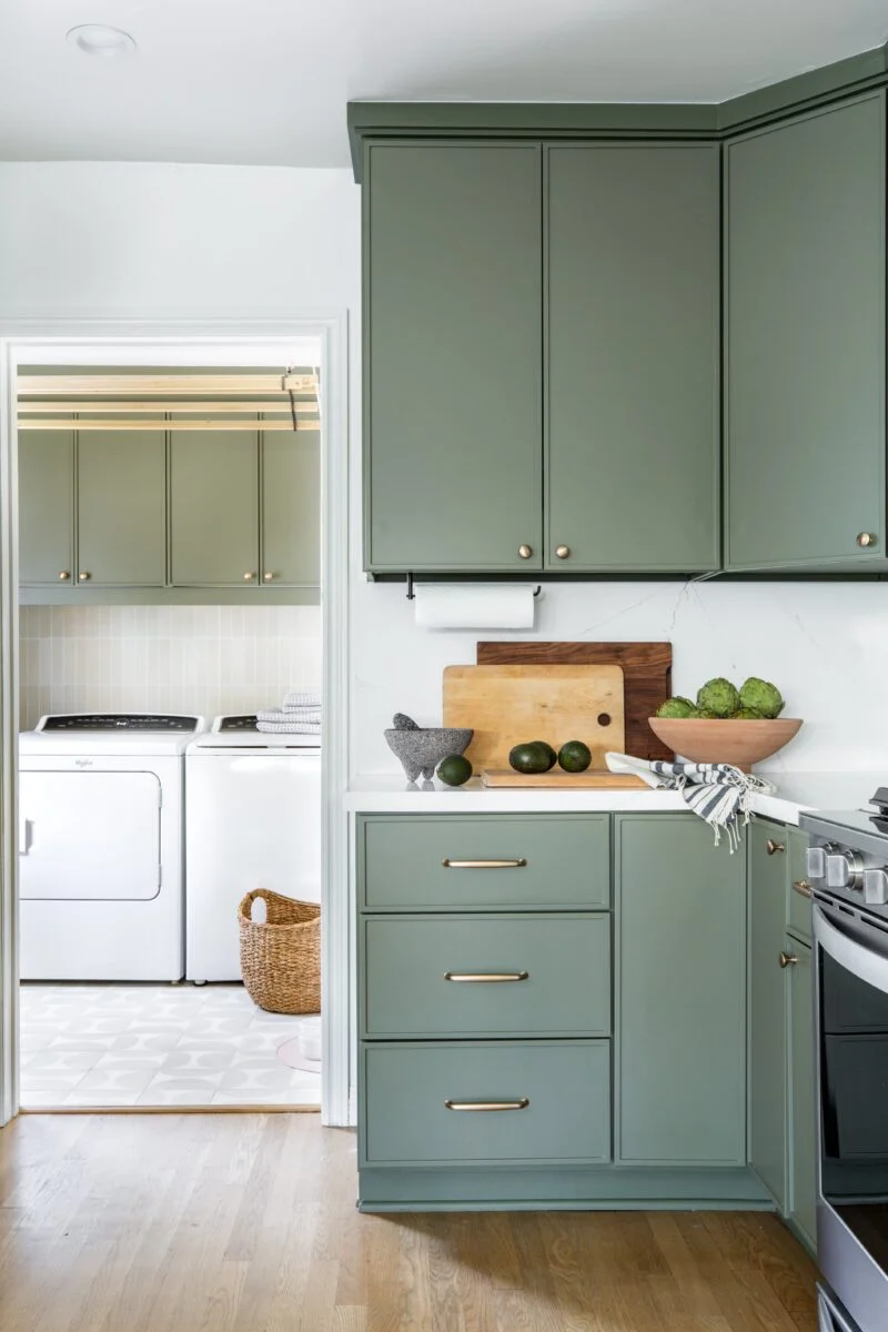 Simple small kitchen with green emerald cabinets and white walls, and wood floor