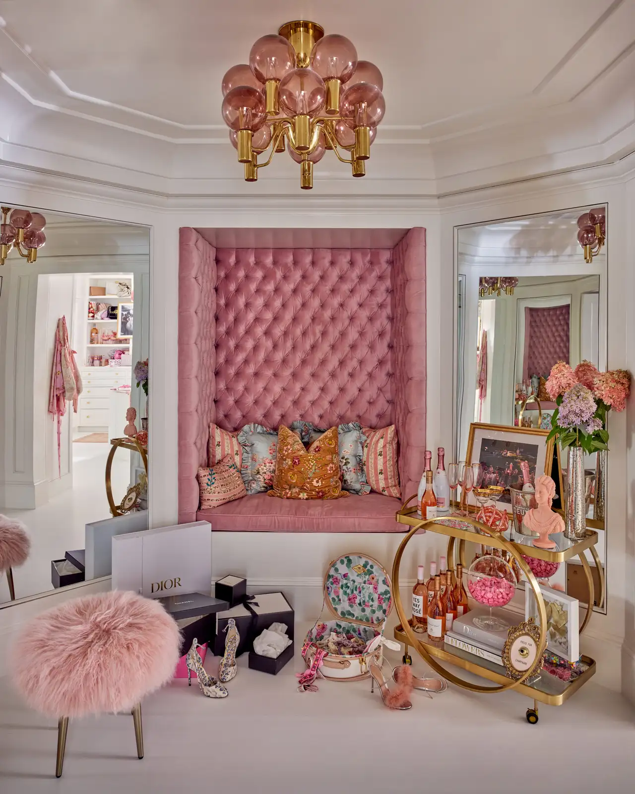 A maximalist closet in white, pink and gold tones