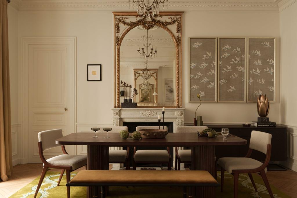 Parisian dining room with dark wood table, antique mirror, and botanical wall art.