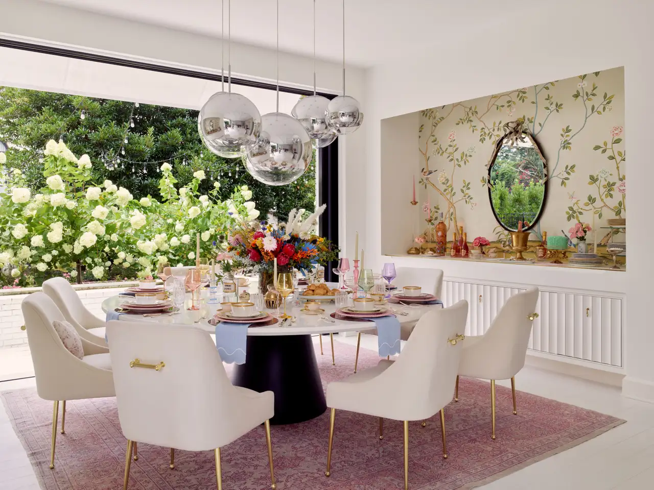 A maximalist dining room with a big silver balls suspension lamp