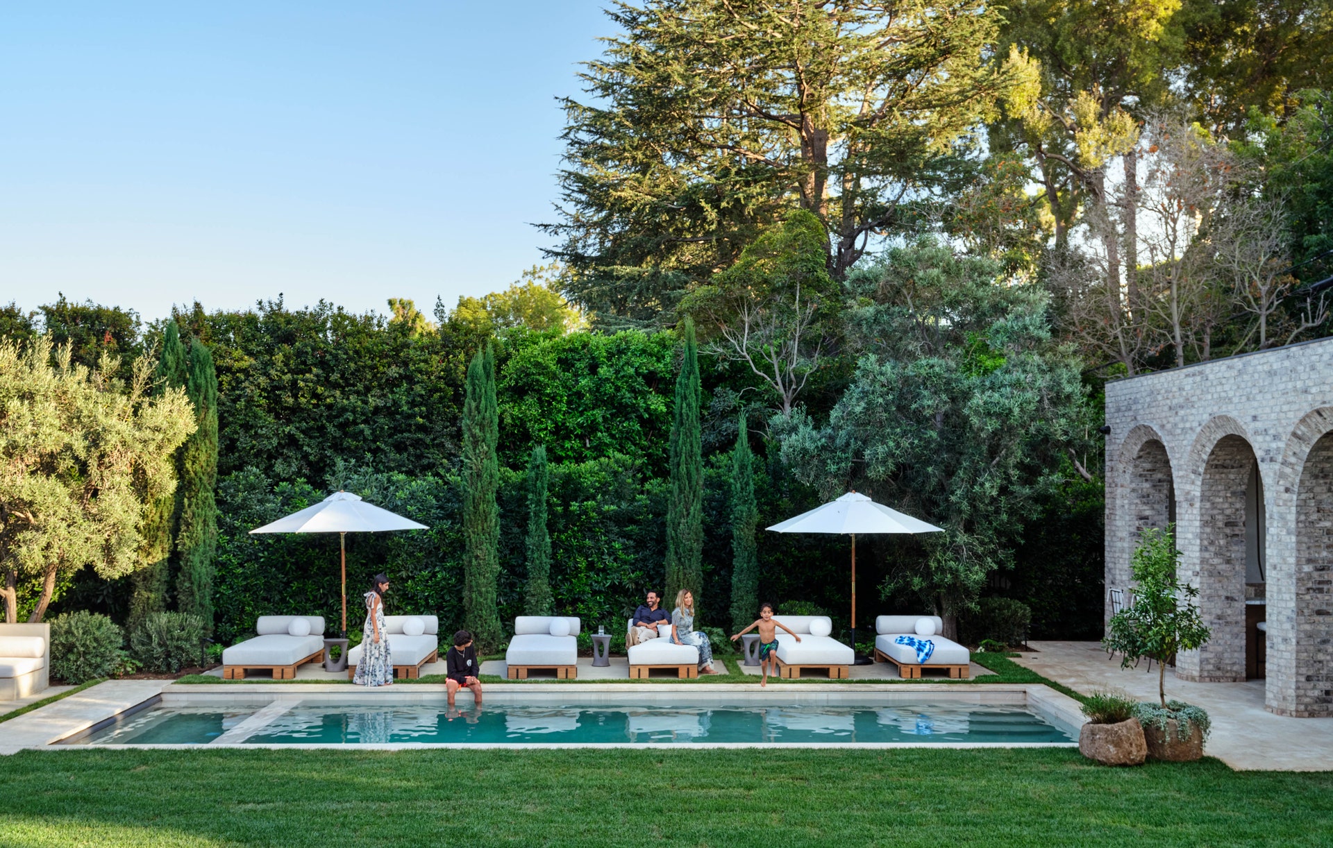 poolside with antique stone planters and umbrellas