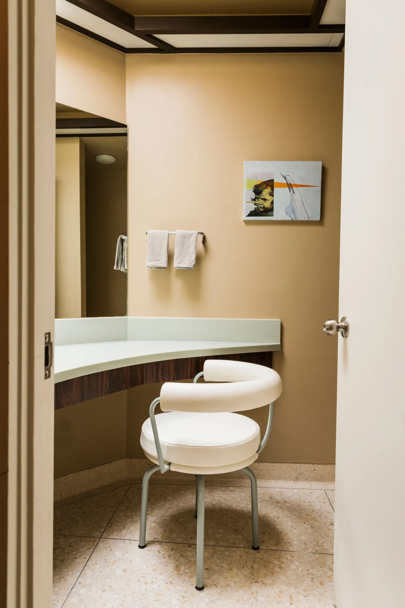 A mid-century bathroom with original floors and built-in cabinetry.