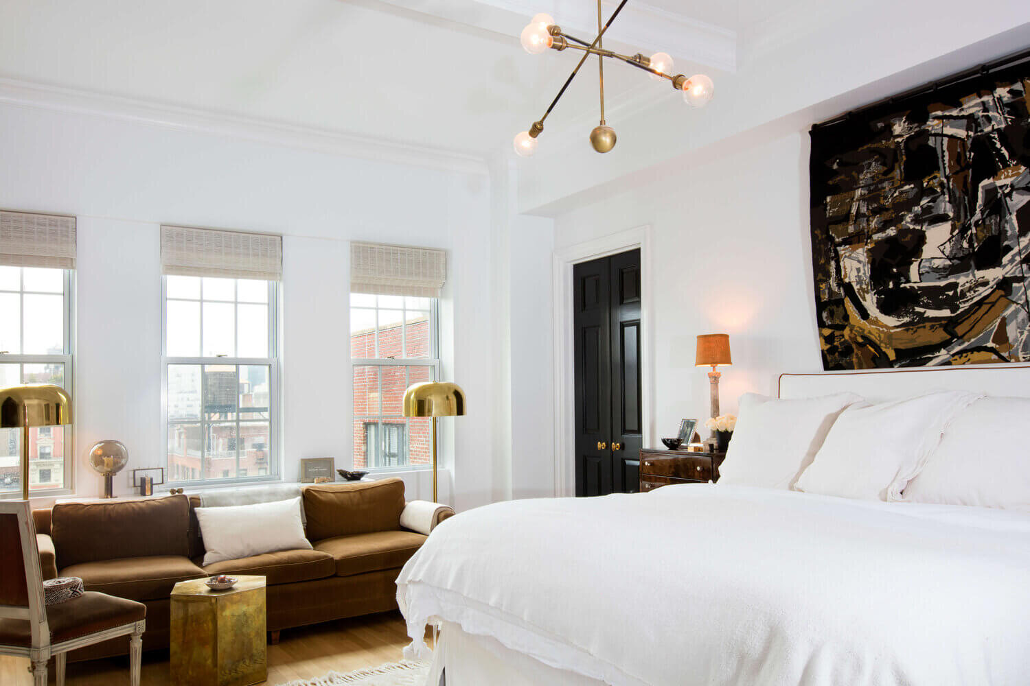 a white bedroom with a brown sofa designed by nate berkus & jeremiah brent 