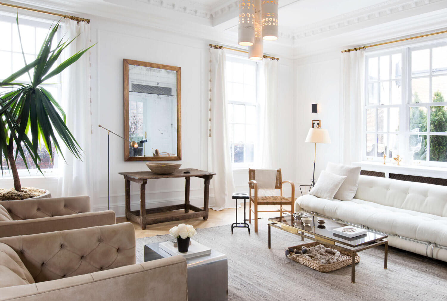 a nude living room with a white sofa and wood furniture designed by Nate Berkus & Jeremiah brent 