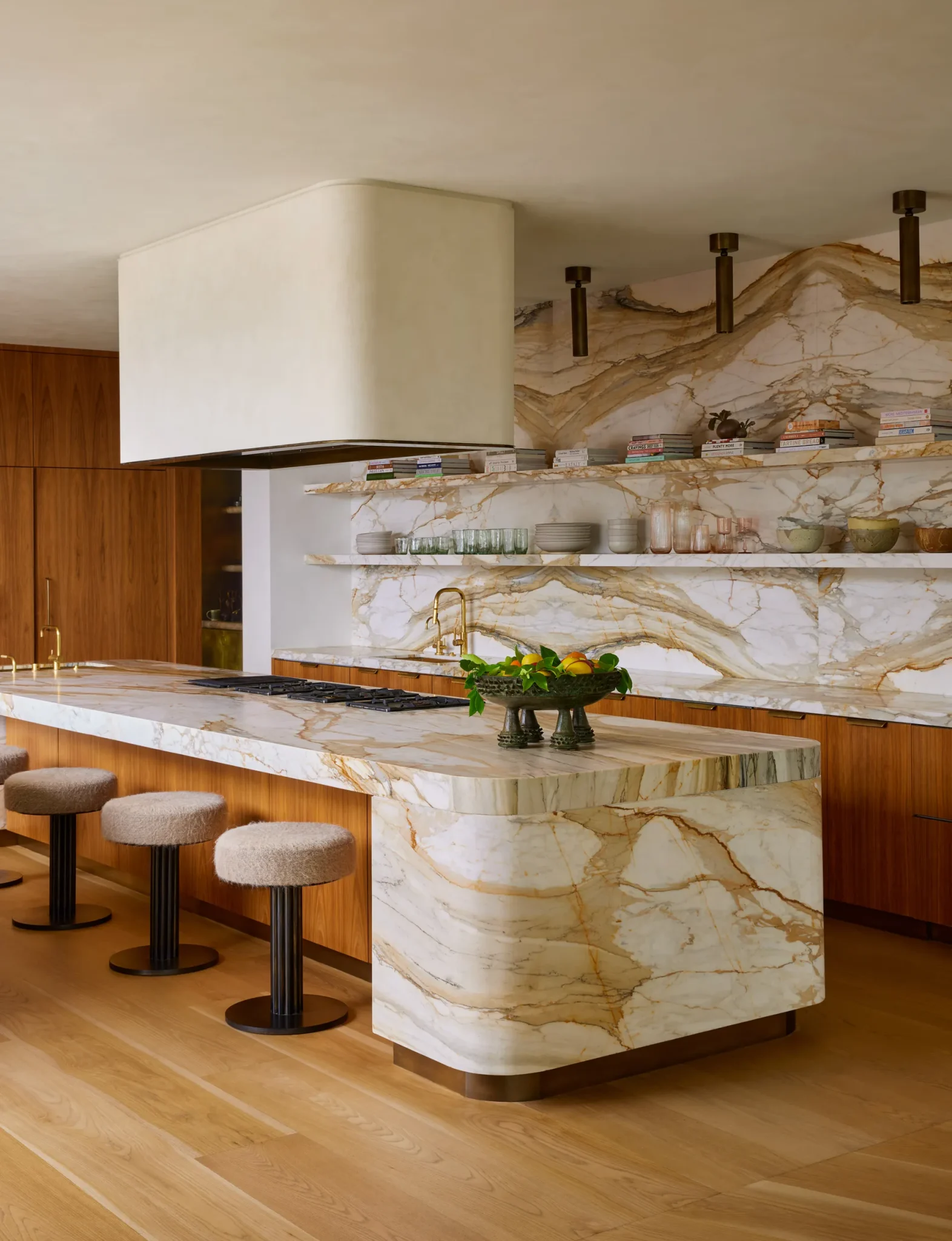 open kitchen with a marble island, stools and apparatus lights 