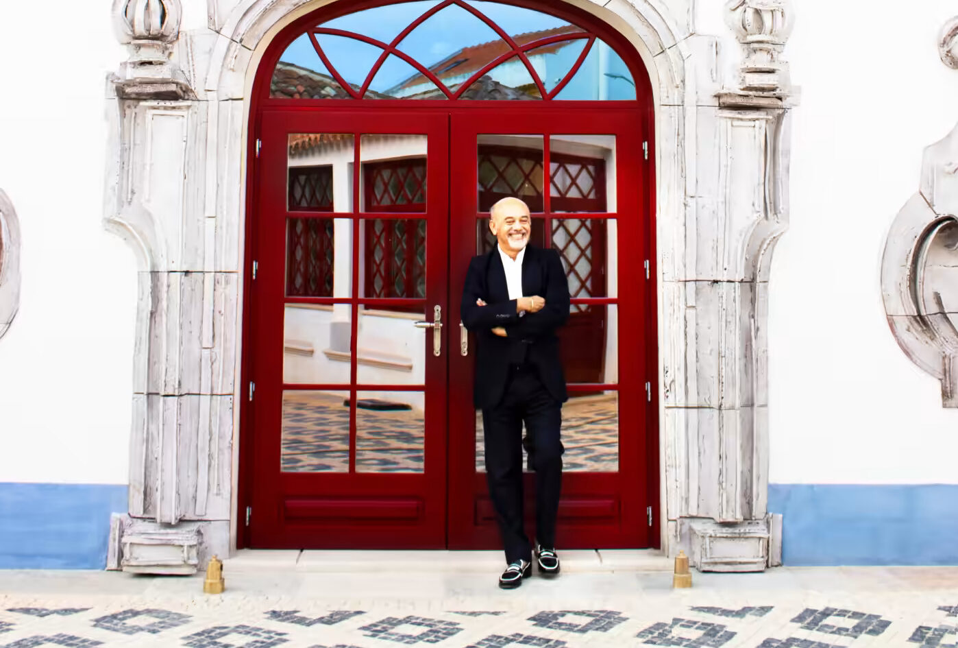 Christian Louboutain standing in front of his Hotel