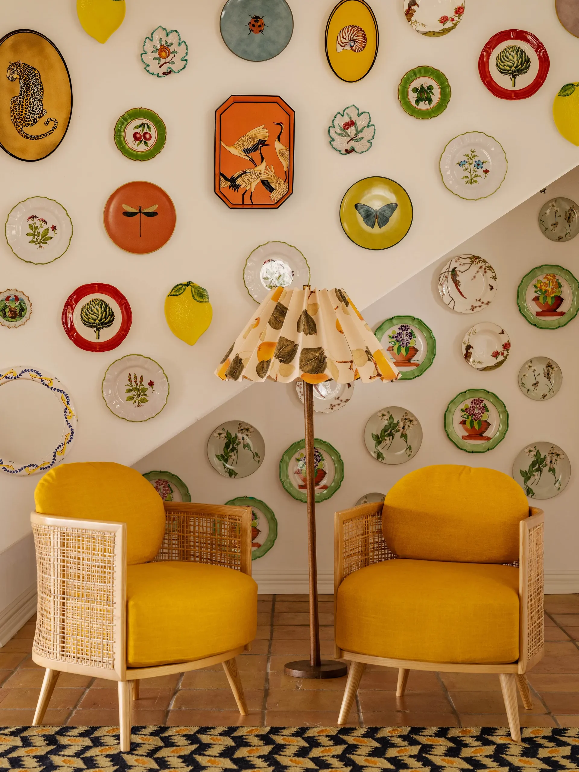 entryway with yellow armchairs and a wall with colorful plates