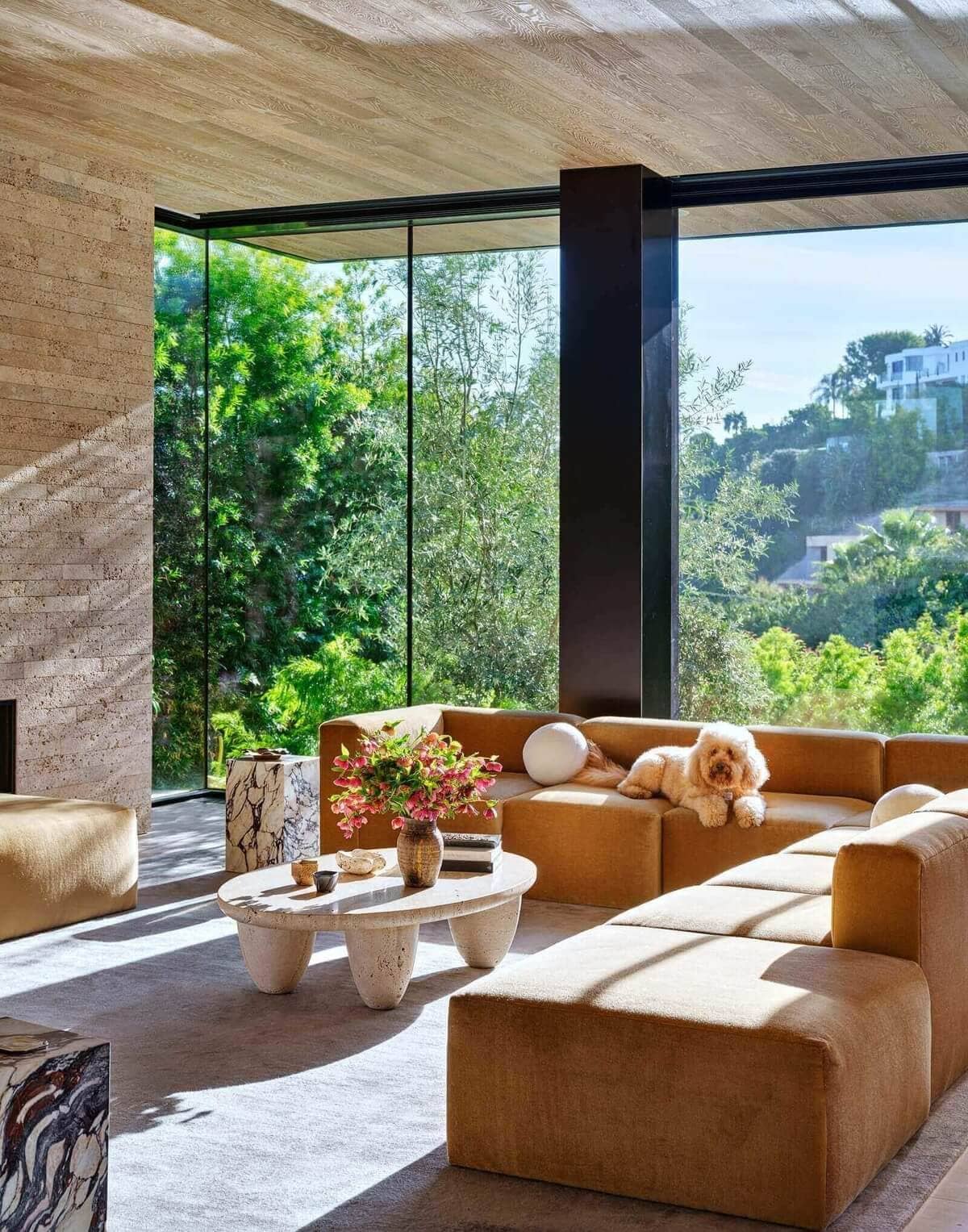 Nate Berkus & Jeremiah Brent Style a Hommés Studio Round Travertine Coffee Table on Brian Robbins and Tracy James New Home In Beverly Hills