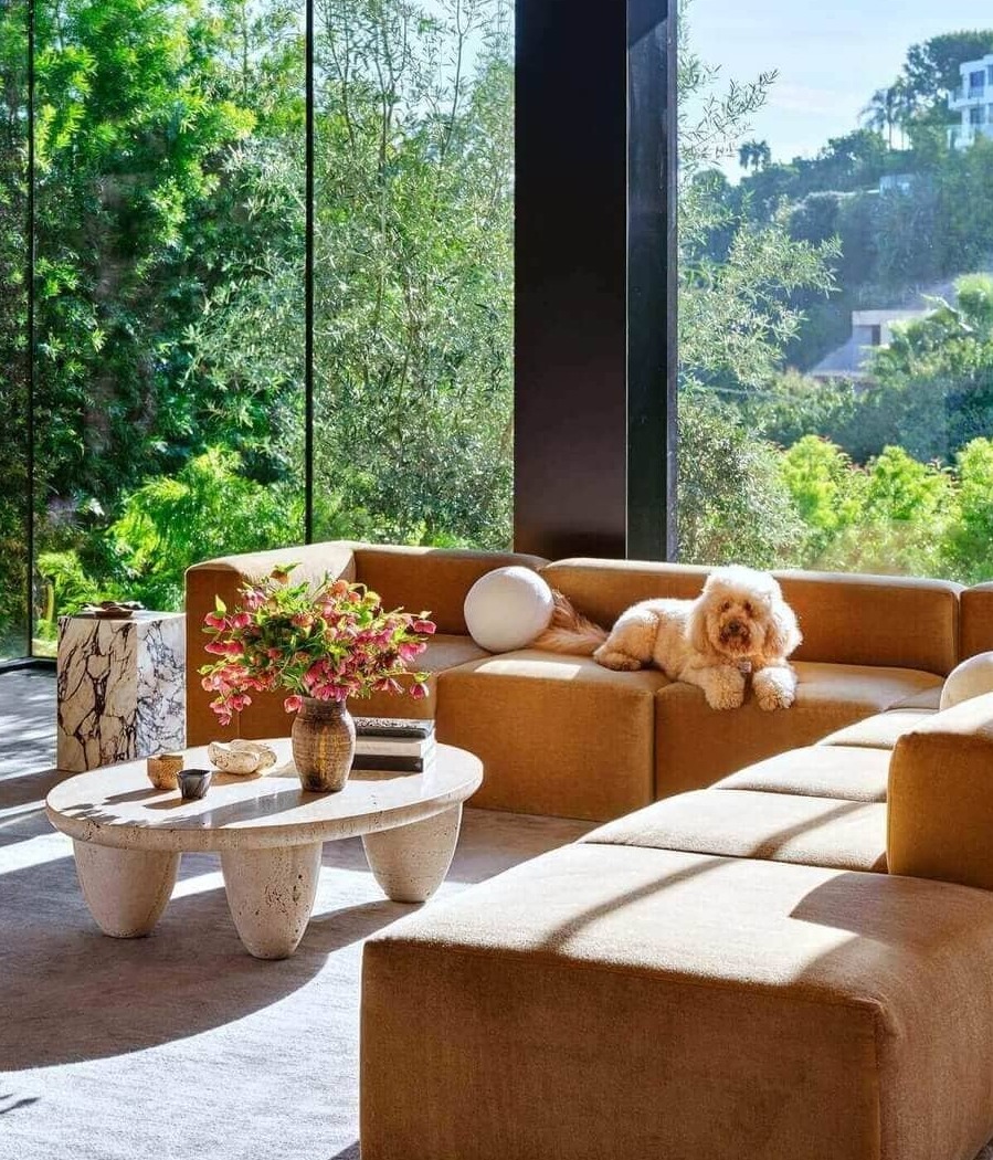 modern living room with a orange corner sofa and travertine center table