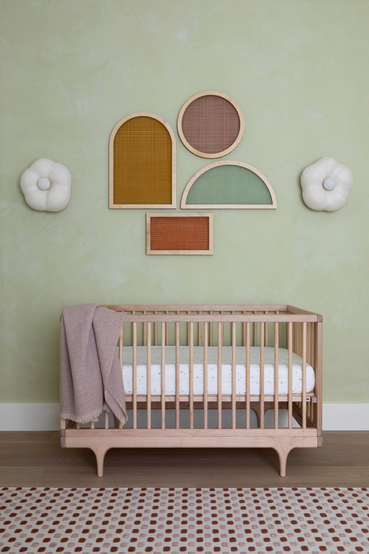 nursery room with a pink crib and green walls