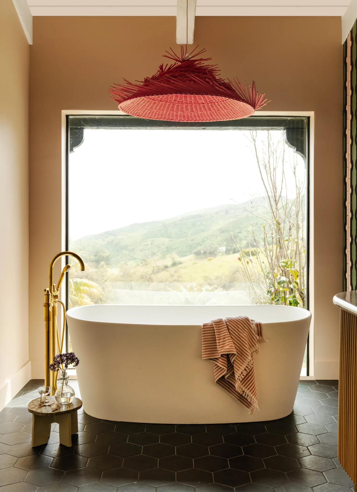primary bathroom with a white bathtub and a hot pink pendant 