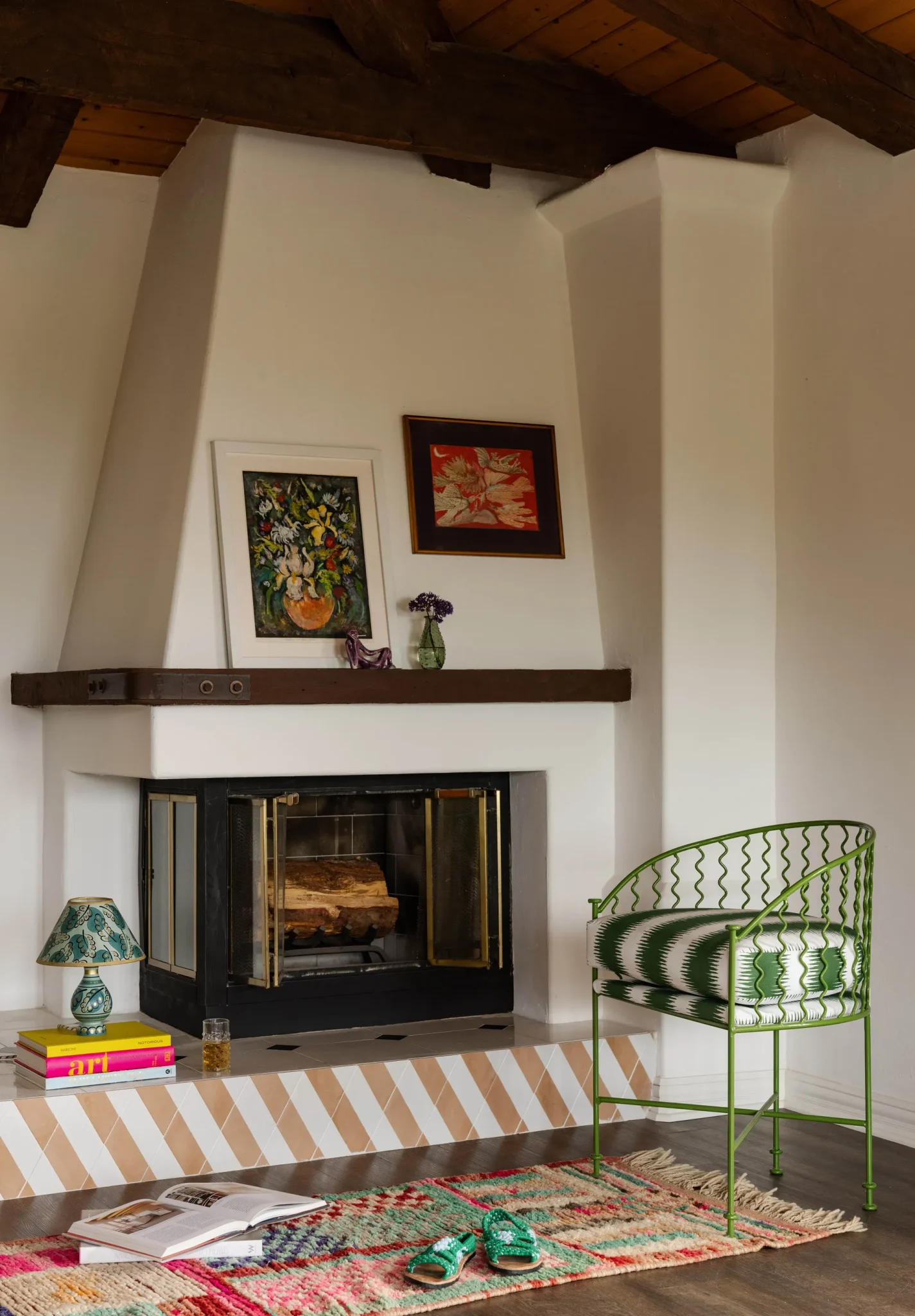 cozy corner of the primary bedroo with a curvy cane armchair 