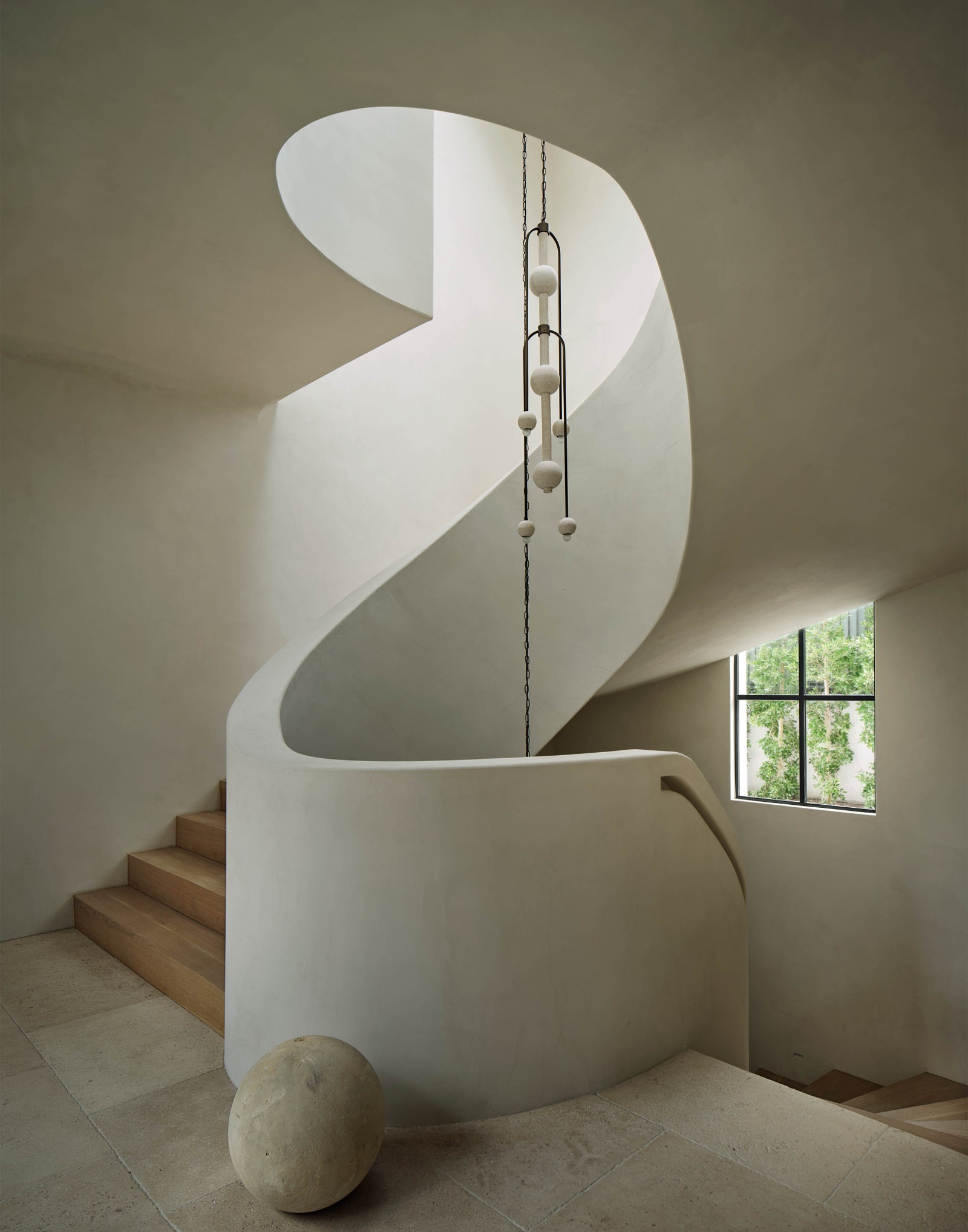 Staircase spirals around a chandelier
