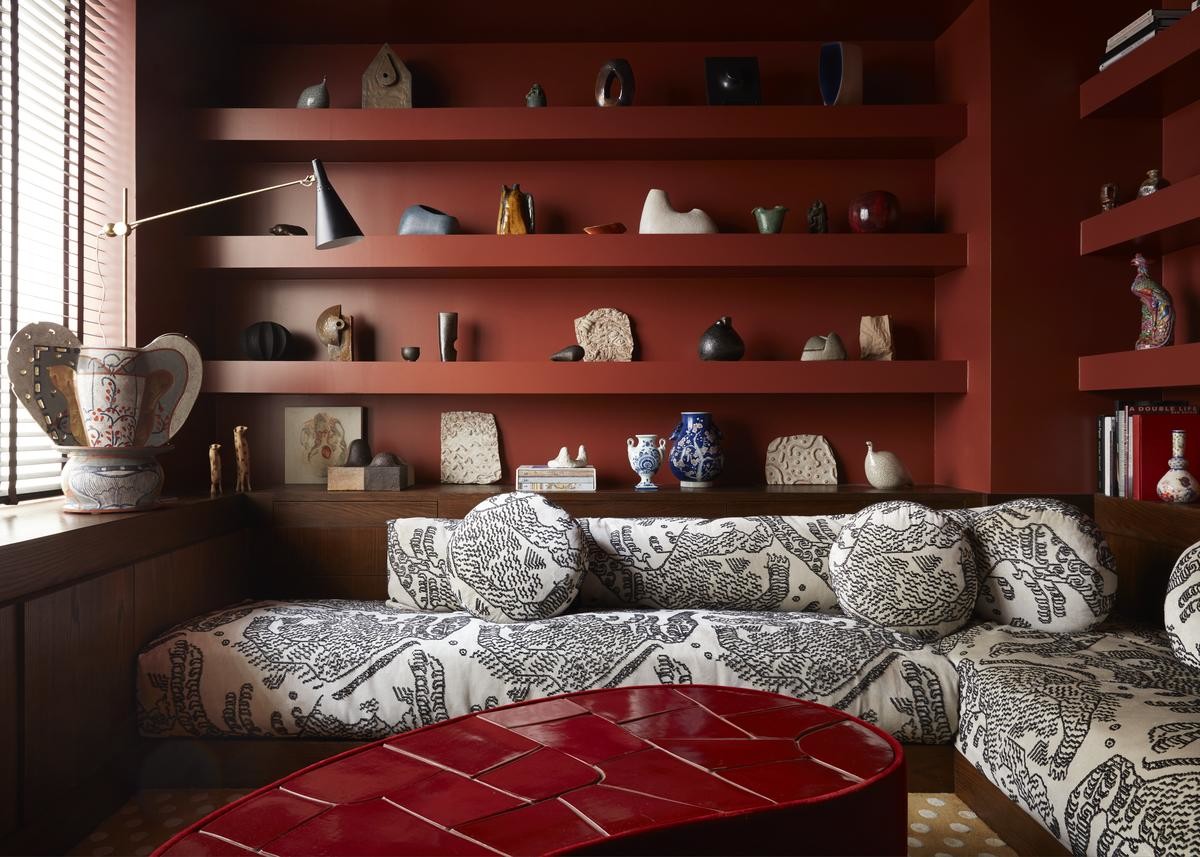 study in deep red hues featuring a curvy center table and a custom sofa in black and white print