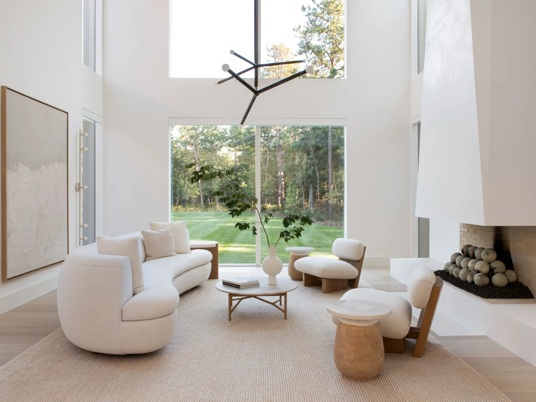 A bright, modern living space in Ulla Johnson's Long Island retreat, featuring a striking geometric chandelier that highlights current lighting trends.