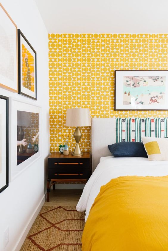 A bedroom with yellow and white geometric design wallpaper
